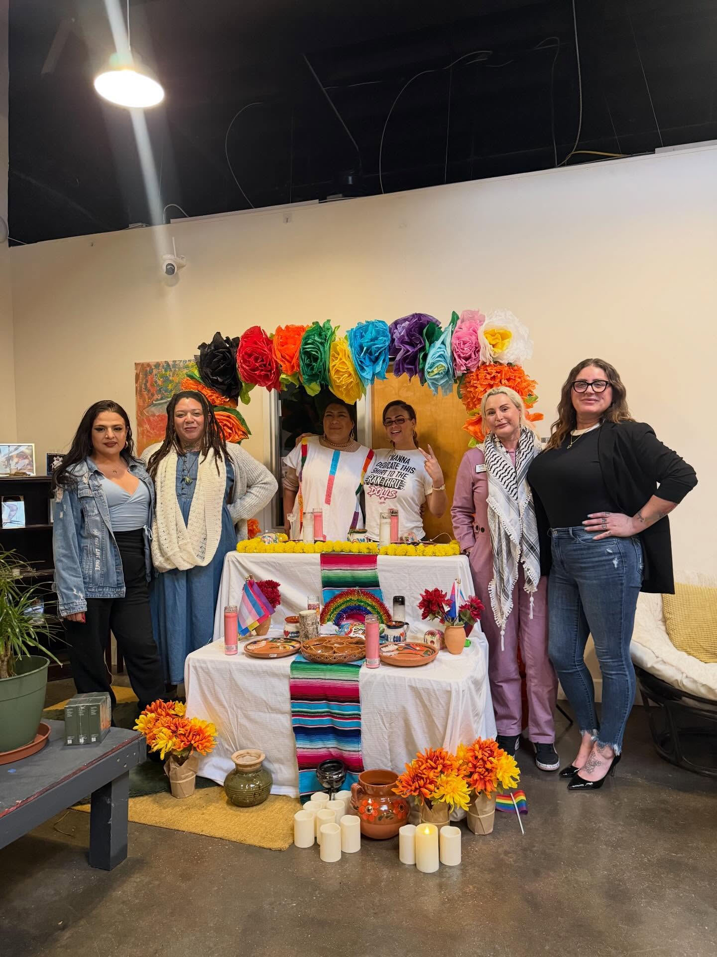 Community members gathered around a colorful trans and queer community altar